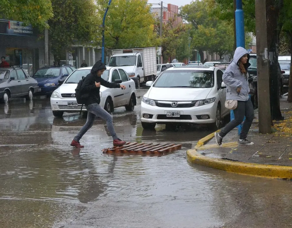 El ingenio de los roquenses para cruzar las calles inundadas de la ciudad. Foto Tania Domenicucci-ANR